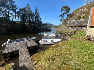 two boats are docked at a dock on a river at Traditional Norwegian Villa, Bay view and boat in Bergen
