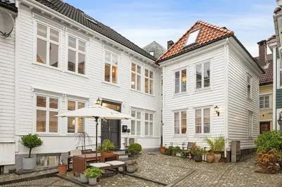 a courtyard with white buildings and an umbrella at Historic House City Centre in Bergen