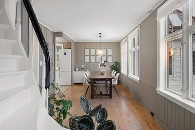 a dining room with a table and some windows at Historic House City Centre in Bergen