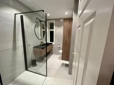 a bathroom with a shower and a sink and a mirror at Historic House City Centre in Bergen
