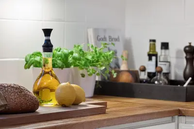 a bottle of wine sitting on a kitchen counter with melons at Historic House City Centre in Bergen