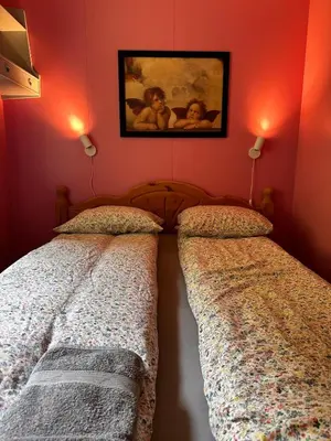two beds in a bedroom with red walls at Family house near Kvitfjell & Hunderfossen in Fåvang