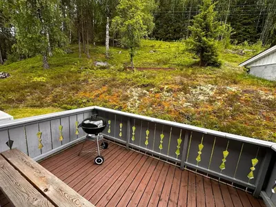 a grill sitting on a porch with a bench on it at Family house near Kvitfjell & Hunderfossen in Fåvang