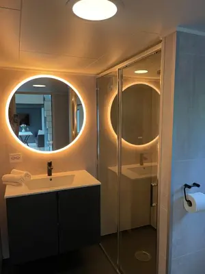 a bathroom with a sink and a shower with a mirror at Olden Tinyhouse - Modern Living in Olden