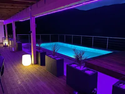 a swimming pool lit up at night with purple lights at Olden Tinyhouse - Modern Living in Olden