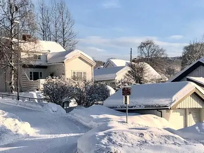 a snow covered street with houses and roofs at 6 person holiday home in Lillehammer in Lillehammer