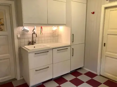 a white kitchen with a sink and white cabinets at 6 person holiday home in Lillehammer in Lillehammer