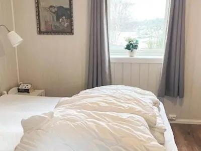 an unmade bed in a bedroom with a window at 8 person holiday home in hauglandshella