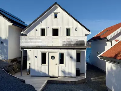 a white house with a white door on a deck at 4 star holiday home in Huglo in Nordhuglo