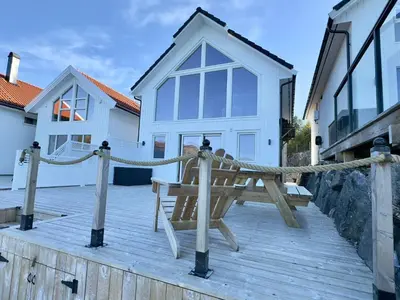 a wooden deck with a bench and a house at 4 star holiday home in Huglo in Nordhuglo