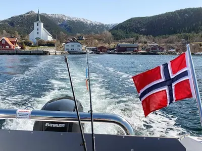 a flag on the back of a boat in the water at 8 person holiday home in Stavang in Stavang