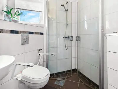 a white bathroom with a shower and a toilet at 8 person holiday home in Stavang in Stavang