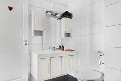 a white bathroom with a sink and a toilet at Cosy authentic apartment, only 60m from Bryggen! in Bergen