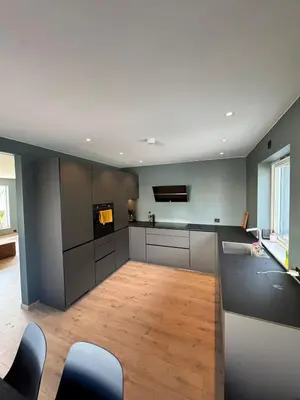 a kitchen with gray cabinets and a wooden floor at House with outdoor area in Ålesund