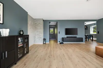 a living room with blue walls and a television at House with outdoor area in Ålesund