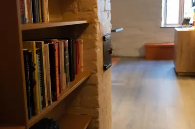 a book shelf filled with books on a brick wall at Private Apartment in Bergen in Bergen