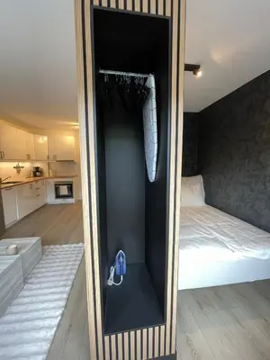 a small bedroom with a bed and a mirror at Modern apartment ONLY 5 minutes from City centre in Bergen