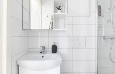 a white bathroom with a sink and a mirror at Modern apartment ONLY 5 minutes from City centre in Bergen