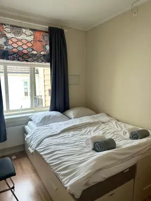 a large bed in a bedroom with a window at Koselig bygårdsleilighet i Bergen sentrum in Bergen