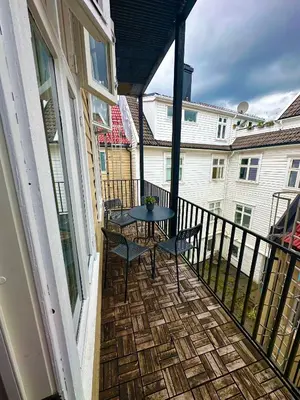 a patio with a table and chairs on a balcony at Koselig bygårdsleilighet i Bergen sentrum in Bergen