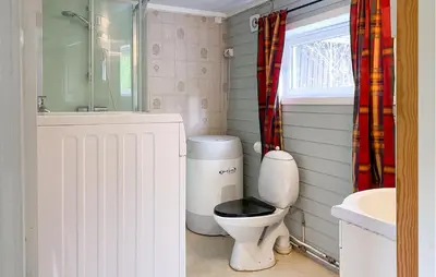 a bathroom with a toilet and a sink and a window at Stunning Home In Eidsvåg I Romsdal in Toven