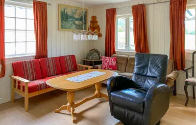 a living room with a couch and a table at Stunning Home In Eidsvåg I Romsdal in Toven