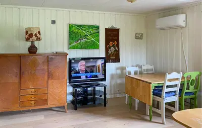 a living room with a tv and a table with chairs at Stunning Home In Eidsvåg I Romsdal in Toven