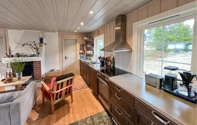 a kitchen with wooden cabinets and a large window at 2 Bedroom Cozy Home In Sjusjøen in Sjusjøen