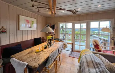 a dining room with a large wooden table with chairs at 2 Bedroom Cozy Home In Sjusjøen in Sjusjøen
