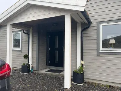 a front door of a house with two potted plants at Atlantis cabin with sauna and great views in Vevang