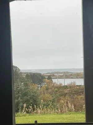 a window with a view of a field and a river at Atlantis cabin with sauna and great views in Vevang