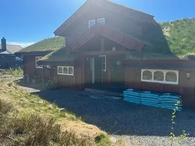 a house with a grass roof with a pile of towels at Modern Cabin With Views In Lygna in Jaren