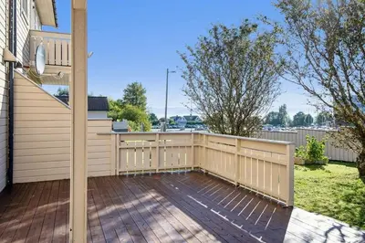 a backyard with a fence and a wooden deck at Furnished apartment near Aker Solutions in Stord