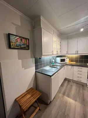 a kitchen with white cabinets and a sink and a bench at Furnished apartment near Aker Solutions in Stord