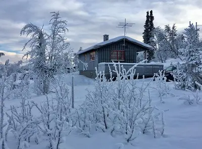 a cabin with snow on the ground in front of it at Koselig, lita hytte på Aurdalsåsen ved Danebu in Aurdal