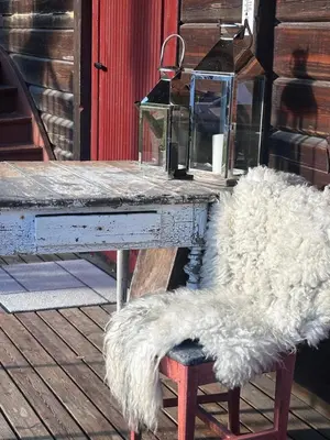 a white table with a bench with a white faux furussion at Nord-Garthus, leilighet 2 in Hølera