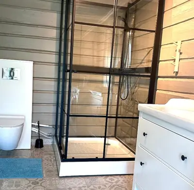 a shower with a glass door in a bathroom at Nord-Garthus, leilighet 2 in Hølera