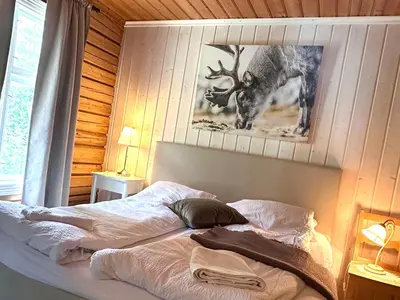 a bed in a bedroom with a picture of a deer at Nord-Garthus, leilighet 2 in Hølera