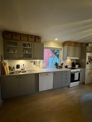 a kitchen with white cabinets and white appliances at Location, location, location in Ervik