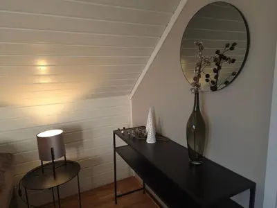 a black table with a vase and a mirror at Trines Hjerterom in Steinkjer