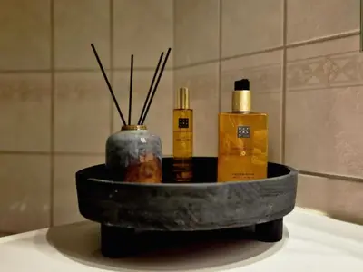 a tray with two bottles of soap and sticks in a bathroom at Trines Hjerterom in Steinkjer
