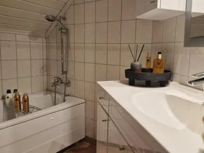 a bathroom with a sink and a bath tub at Trines Hjerterom in Steinkjer