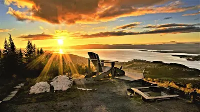 a view of a sunset with a chair and a lake at Trines Hjerterom in Steinkjer