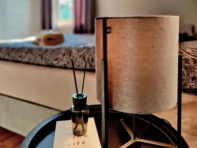 a lamp on a table next to a bed at Trines Hjerterom in Steinkjer