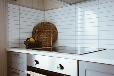 a kitchen with white tiled walls and a counter top at Beach apartment with unique view in Ervik