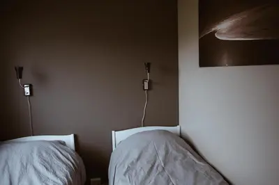 a bedroom with two beds with white sheets on them at Beach apartment with unique view in Ervik