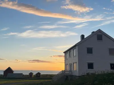 a white house with the ocean in the background at Location, location, location in Ervik