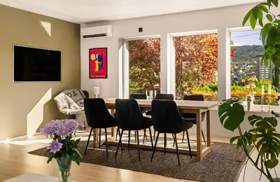 a living room with a dining room table and chairs at Lille Luxury moderne feriehus med stor uteplass, utekjøkken og pergola in Bergen