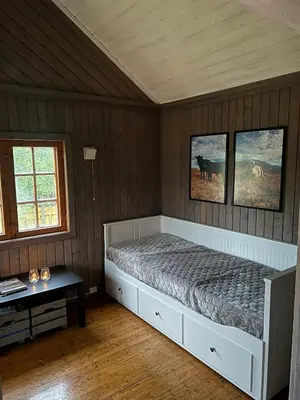 a bedroom with a bed and two pictures on the wall at Koselig hytte på hugastølen in Vang I Valdres