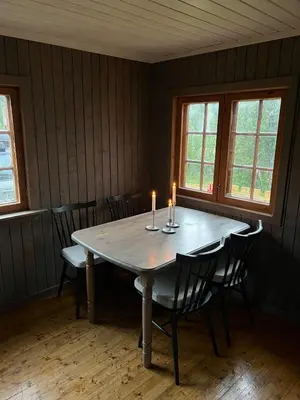 a dining room with a table with two candles on it at Koselig hytte på hugastølen in Vang I Valdres